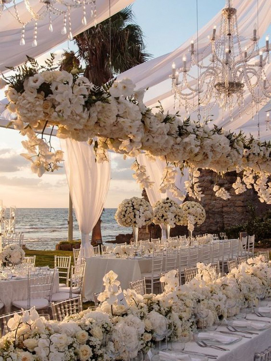 Oceanfront Tented Reception with Chandeliers and White Florals Oceanfront tented wedding reception with white florals and chandeliers at sunset in Southern California