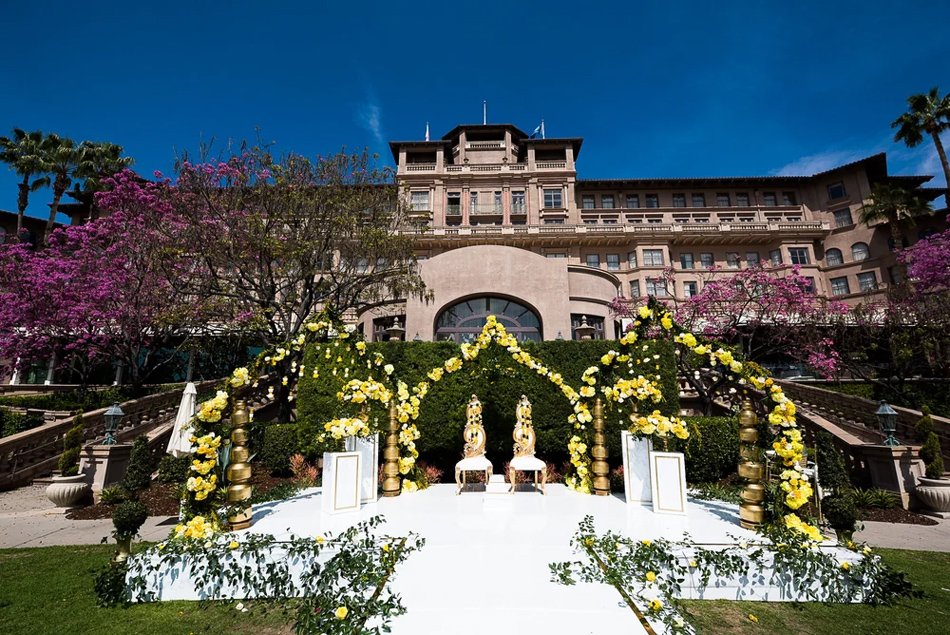 Langham Pasadena Garden Mandap Ceremony Indian wedding mandap at The Langham Pasadena with yellow floral arches and historic terrace backdrop.