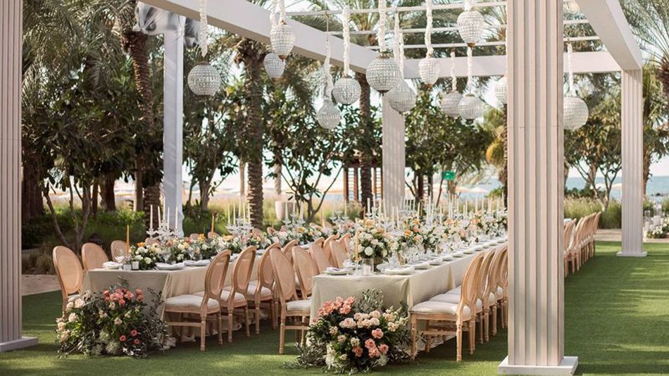 Four Seasons Los Angeles Outdoor Garden Reception Al-fresco reception at a luxury LA resort with long tables, neutral linens, and crystal orbs under a pergola.