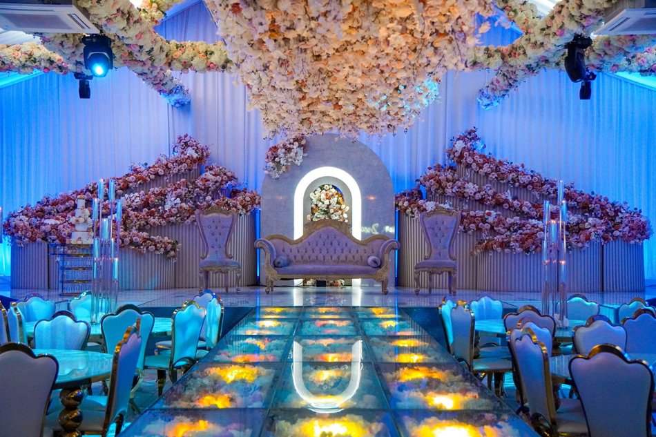Opulent Los Angeles ballroom wedding reception with hanging florals and glass details.