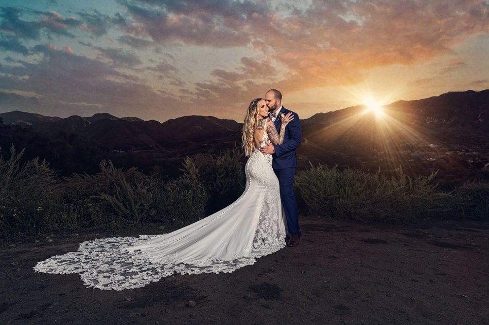 Bride and groom sharing romantic kiss in garden with flowing veil during Los Angeles wedding