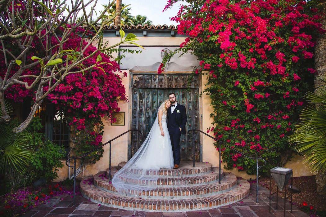 Elegant bride walking through Royal Palms Resort garden arches