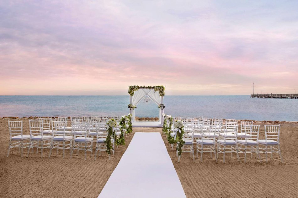 San Diego Beachfront Wedding Ceremony at Sunset Elegant beachfront ceremony in San Diego with white aisle, chiavari chairs, and pastel sunset sky.