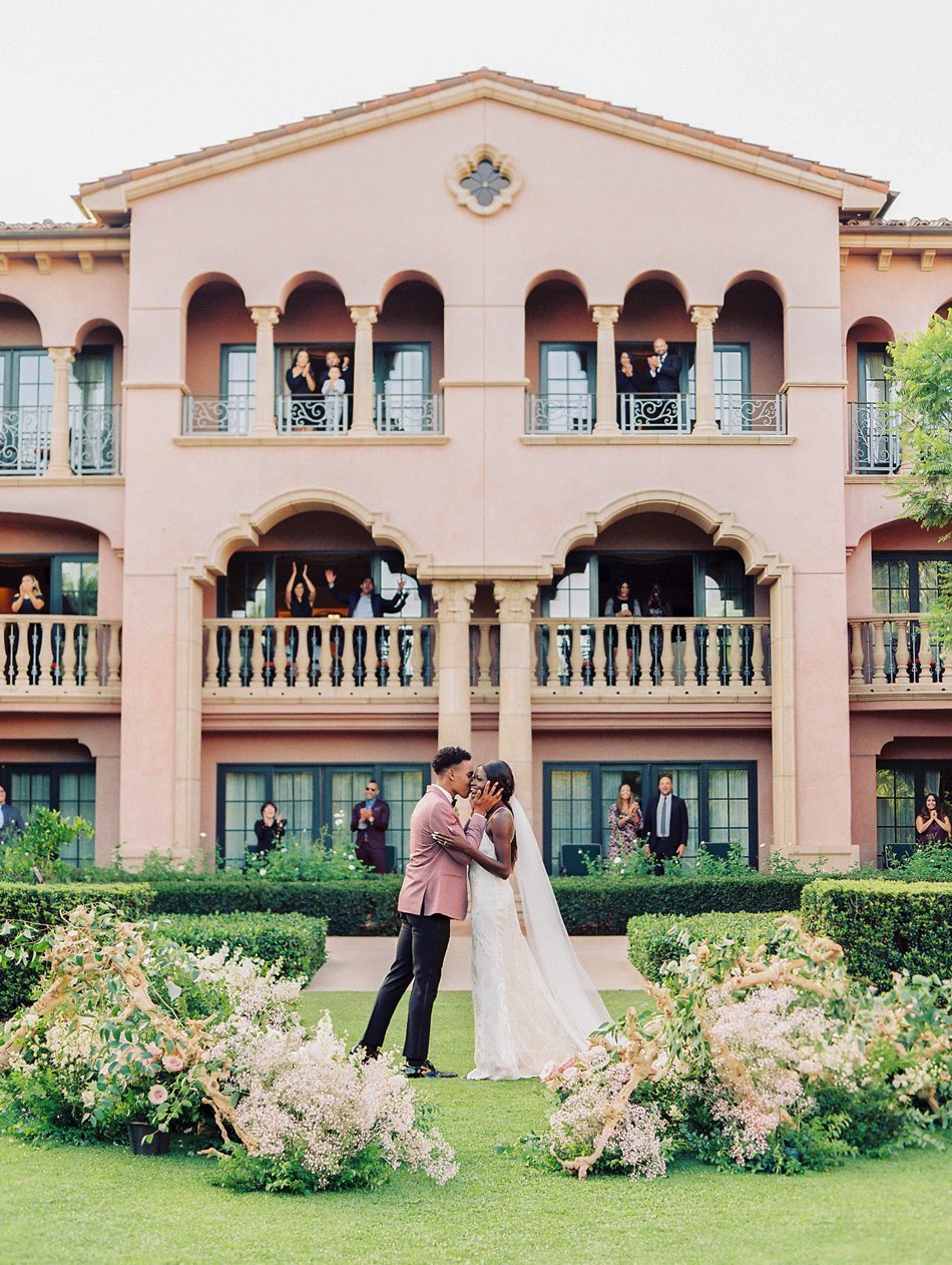 Elegant Southern California waterfront wedding near Phoenix—golden-hour kiss with boats and marina lights.