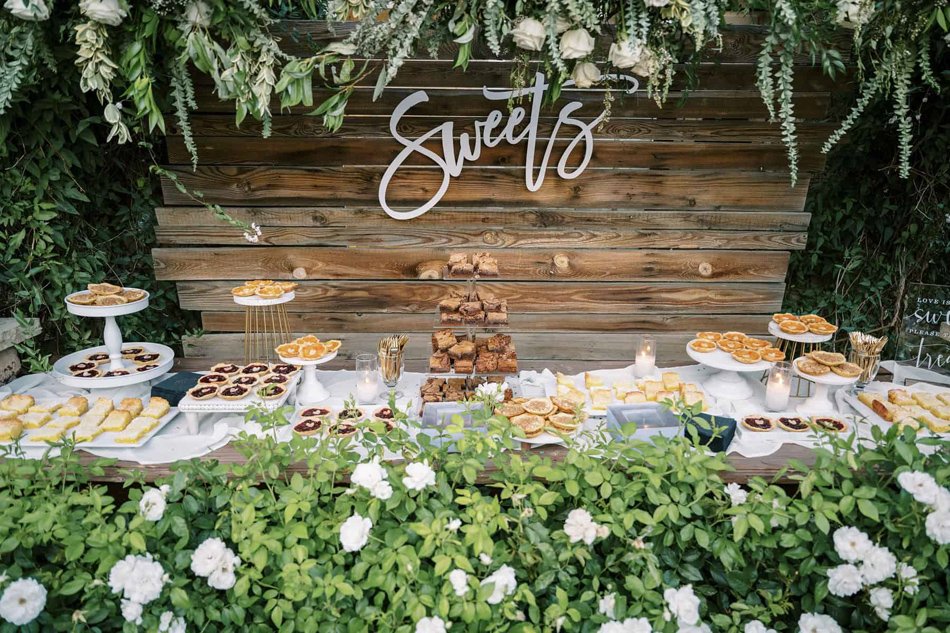 Outdoor dessert display with pies and mini tarts at a Southern California estate wedding reception.