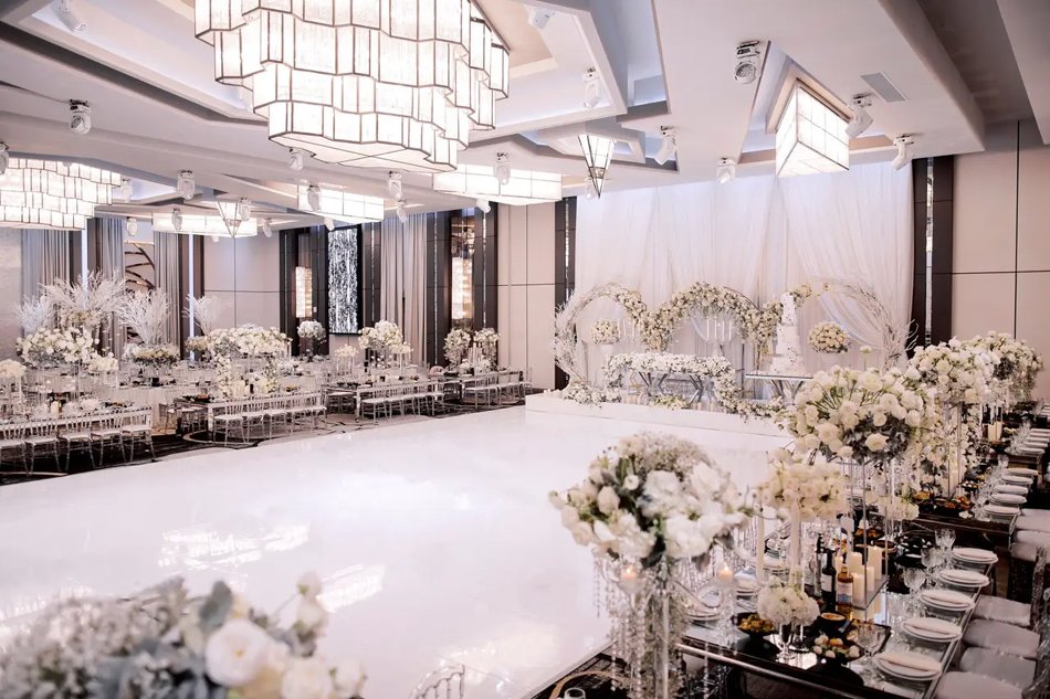 Downtown LA Grand Ballroom Ceremony Large hotel ballroom ceremony with chandeliers, white gloss aisle, and floral arches.
