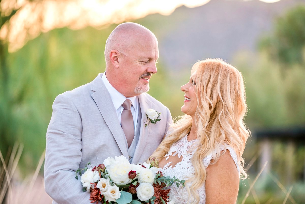 Groom in a gray suit standing with his bride outdoors at a Scottsdale wedding venue