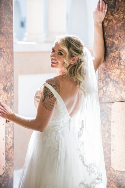 Elegant bridal preparation captured in natural window light. Bride standing by a window in Scottsdale, Arizona before her wedding