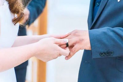 Groom adjusting tie before beachfront ceremony in Ventura, California