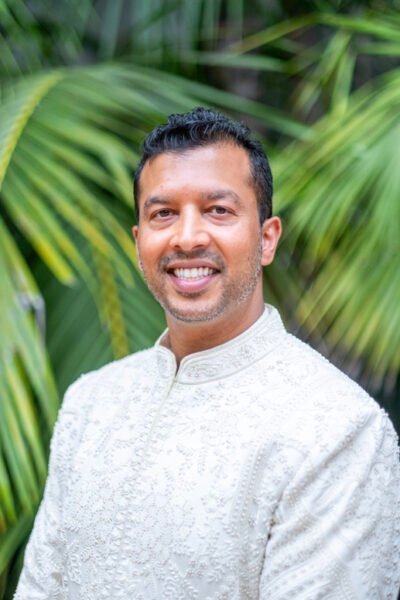 smiling-indian-groom-palm-garden-portrait