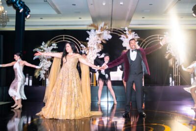 Modern South Asian couple portrait with the bride resting behind the groom in soft white light.